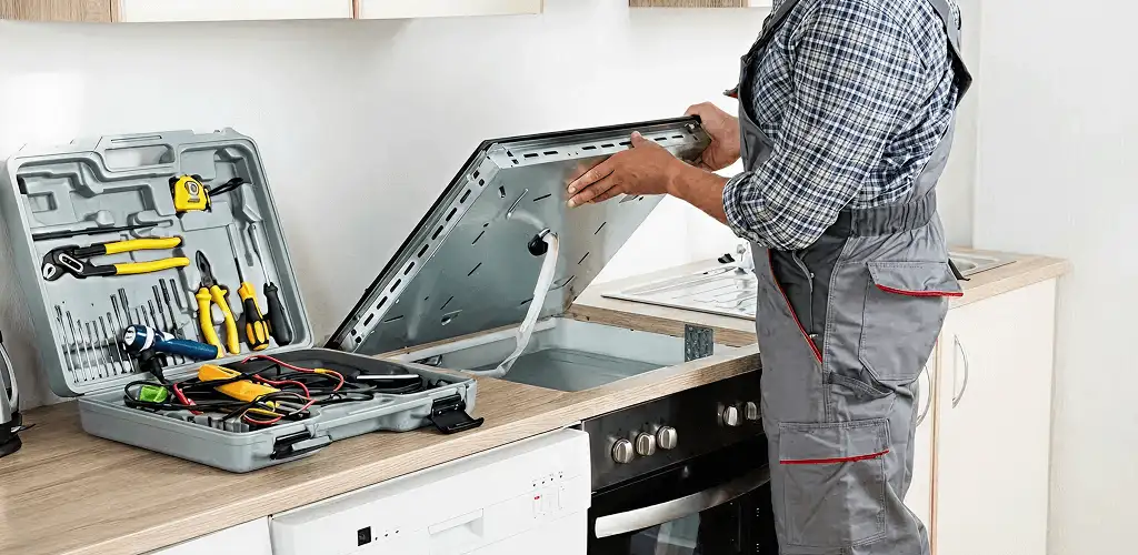 Handyman repairing a cooktop and checking wiring connections in Reno, NV