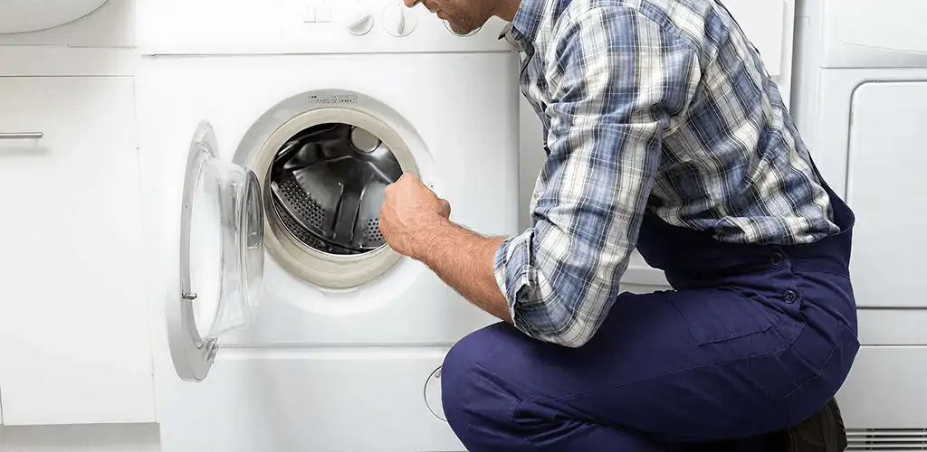 Handyman inspecting a dryer drum and internal parts for repair in Reno, NV