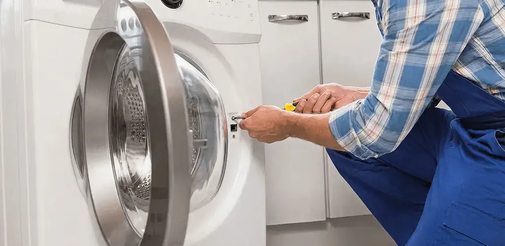 Handyman repairing a clothes dryer and checking electrical connections in Reno, NV