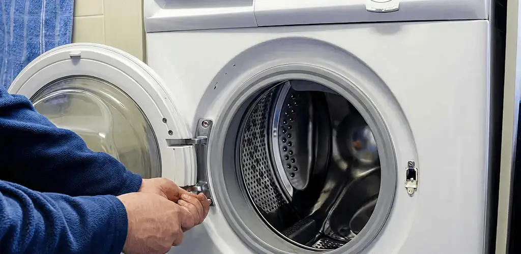 Washing machine repair handyman checking a front-load washer door and latch in Reno, NV