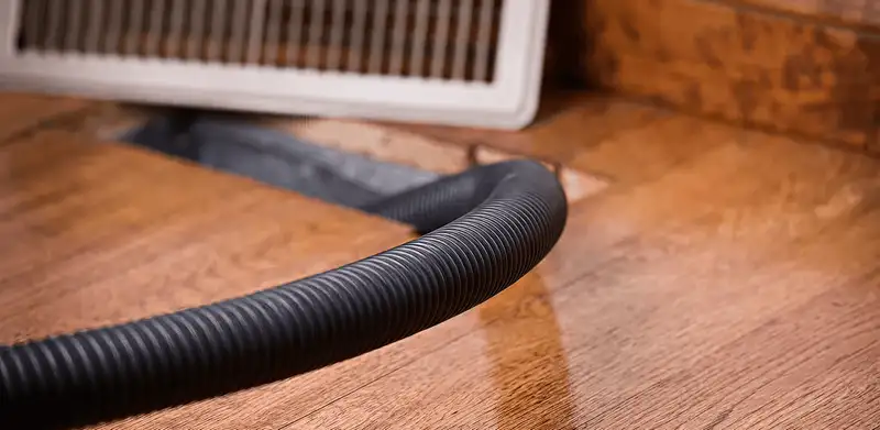 Air duct cleaning hose inserted into a floor vent for ductwork cleaning in Reno, NV