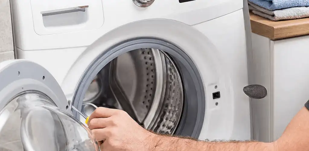 Handyman repairing a front-load washing machine and inspecting the drum in Reno, NV