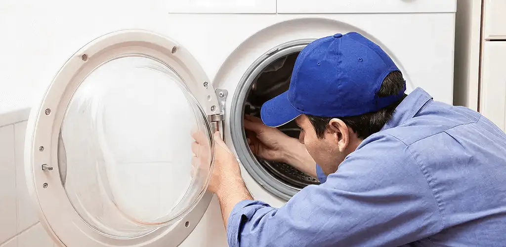 Washing machine repair handyman inspecting a front-load washer drum in Reno, NV