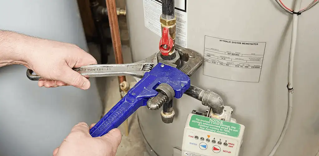 Water heater repair technician tightening the shutoff valve and supply line in Reno, NV